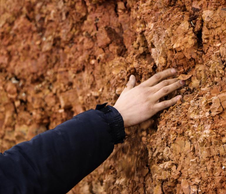Hand touching brown soil