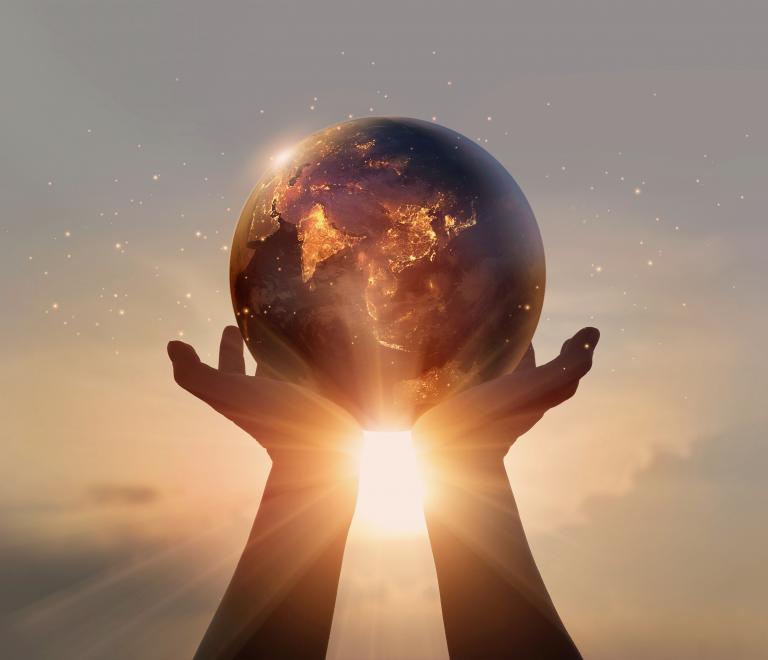 Globe in hands during sunset