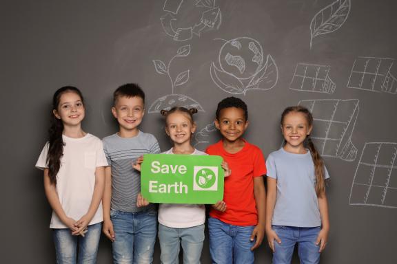 Children holding a sign that says Save Earth
